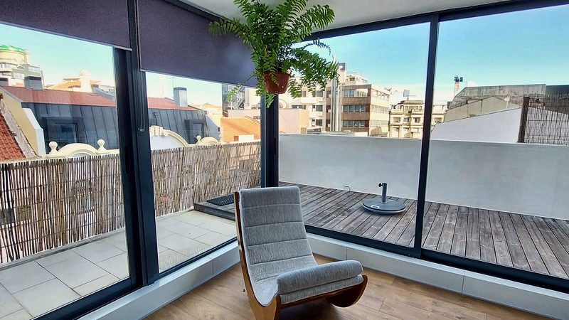 Floor-to-ceiling glass doors opening onto the upper terrace and the rooftops